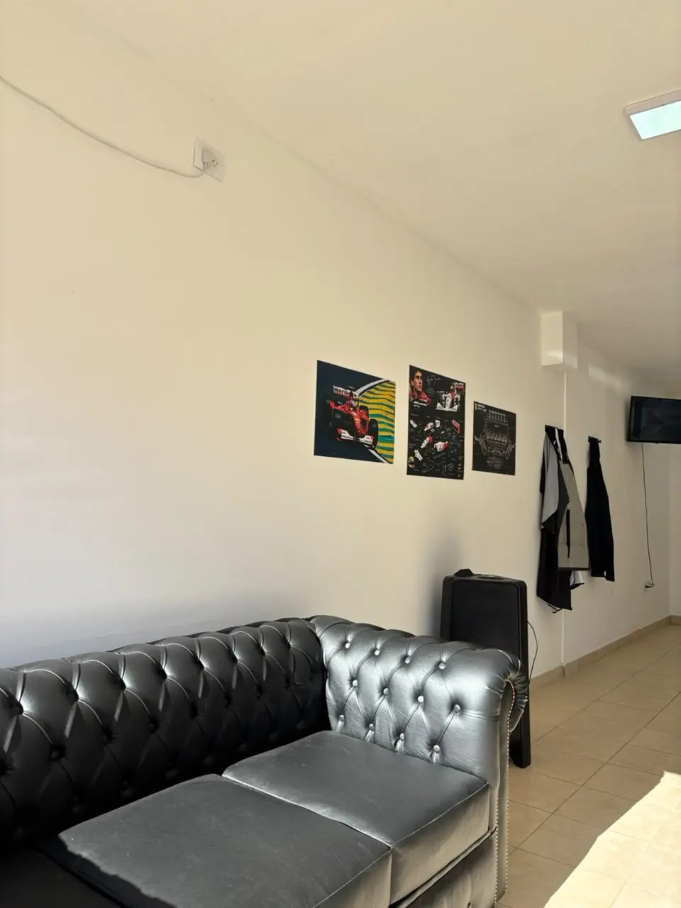 La sala de espera con el Chesterfield negro y los cuadros de Fórmula 1